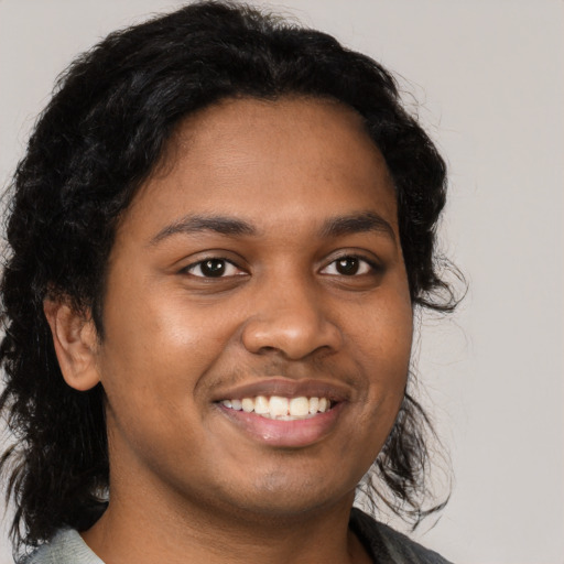 Joyful black young-adult male with medium  brown hair and brown eyes