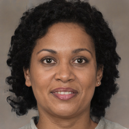 Joyful black adult female with medium  brown hair and brown eyes