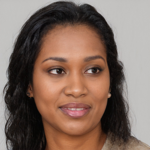 Joyful black young-adult female with long  brown hair and brown eyes