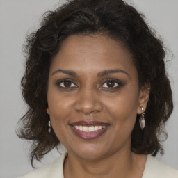 Joyful black adult female with medium  brown hair and brown eyes