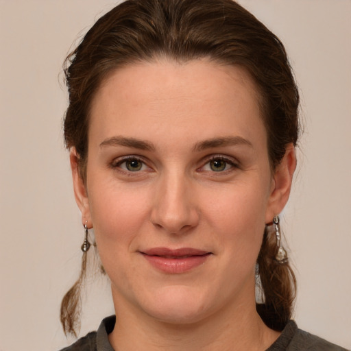 Joyful white young-adult female with medium  brown hair and green eyes