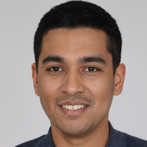 Joyful latino young-adult male with short  black hair and brown eyes