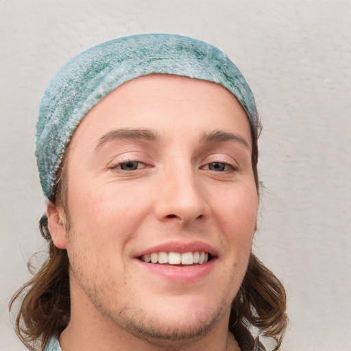 Joyful white young-adult male with short  brown hair and blue eyes