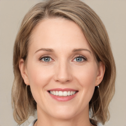 Joyful white adult female with medium  brown hair and green eyes