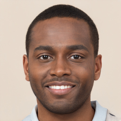 Joyful black young-adult male with short  brown hair and brown eyes