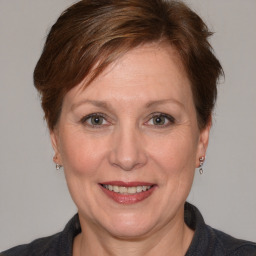 Joyful white adult female with medium  brown hair and blue eyes