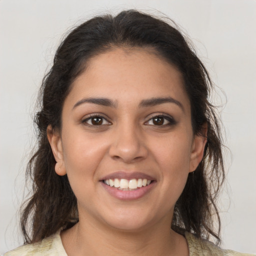 Joyful latino young-adult female with medium  brown hair and brown eyes