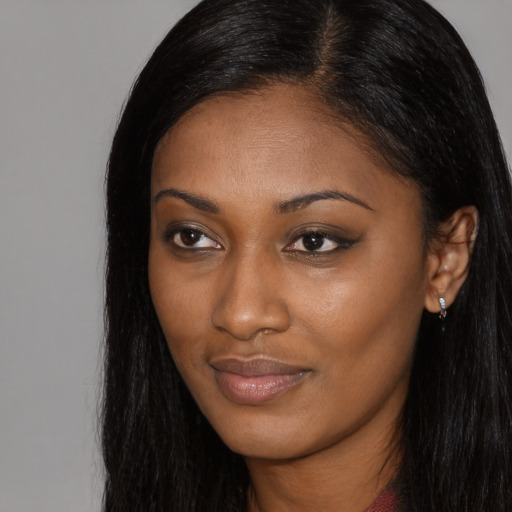 Joyful black young-adult female with long  black hair and brown eyes