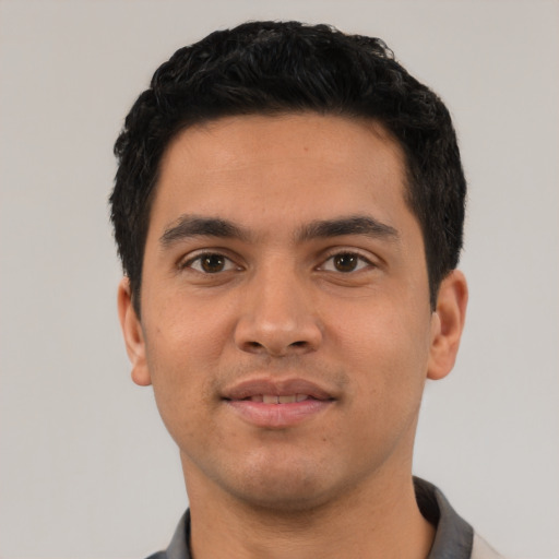 Joyful latino young-adult male with short  black hair and brown eyes