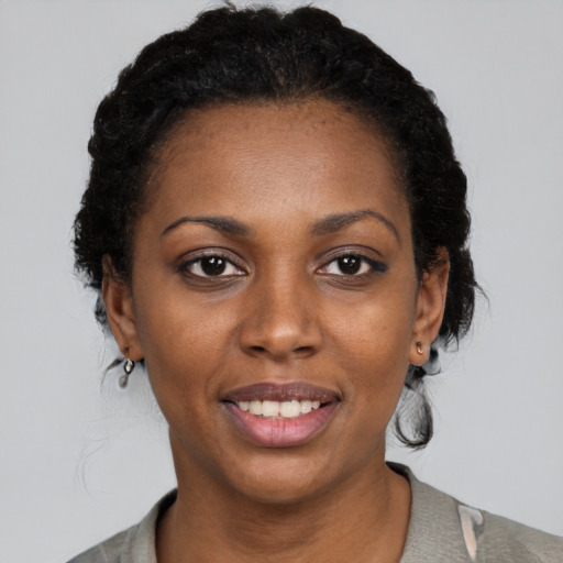 Joyful black young-adult female with medium  black hair and brown eyes