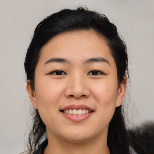 Joyful asian young-adult female with medium  black hair and brown eyes