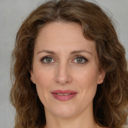 Joyful white adult female with medium  brown hair and green eyes