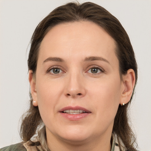 Joyful white young-adult female with medium  brown hair and grey eyes