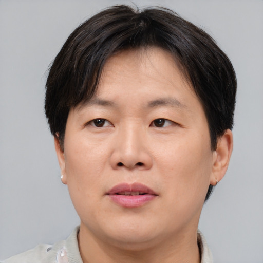 Joyful asian adult male with short  brown hair and brown eyes