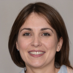 Joyful white adult female with medium  brown hair and grey eyes