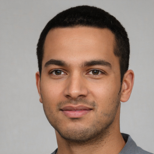 Joyful latino young-adult male with short  black hair and brown eyes