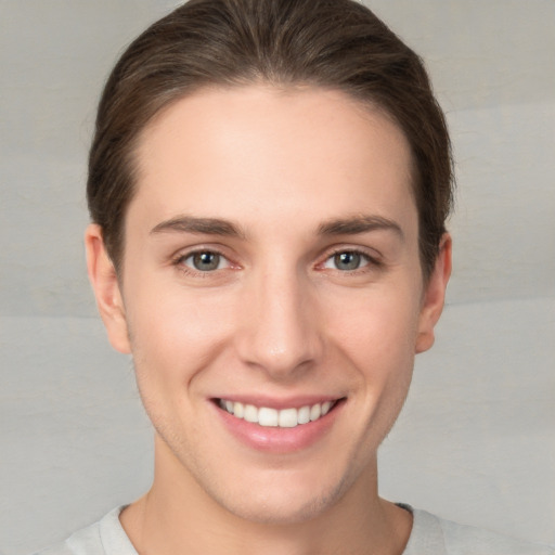 Joyful white young-adult female with short  brown hair and grey eyes