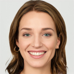 Joyful white young-adult female with long  brown hair and blue eyes