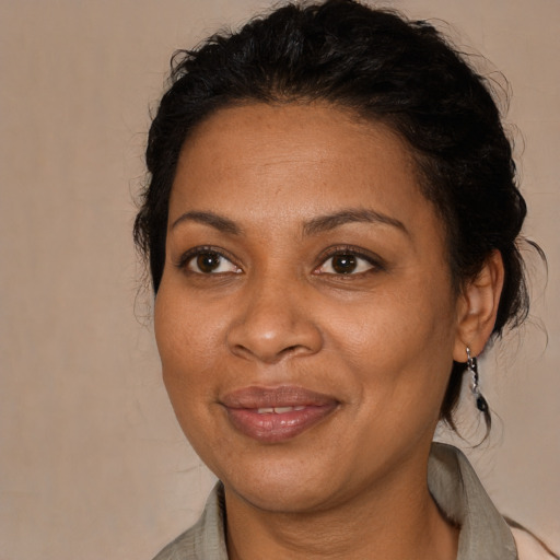 Joyful black adult female with medium  brown hair and brown eyes