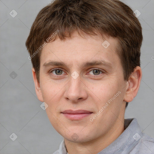 Joyful white young-adult male with short  brown hair and grey eyes