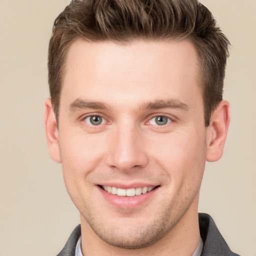 Joyful white young-adult male with short  brown hair and grey eyes