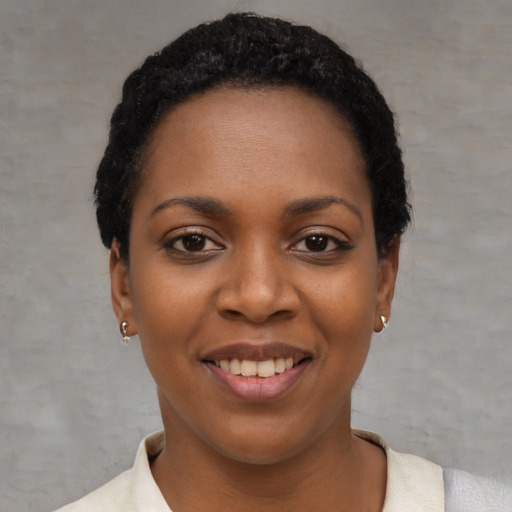 Joyful black young-adult female with short  black hair and brown eyes