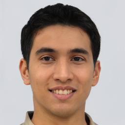 Joyful latino young-adult male with short  brown hair and brown eyes