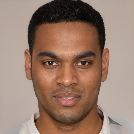 Joyful black young-adult male with short  black hair and brown eyes