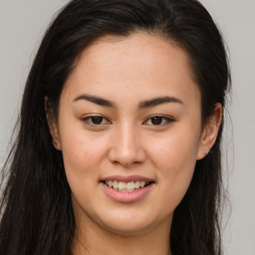 Joyful latino young-adult female with long  brown hair and brown eyes