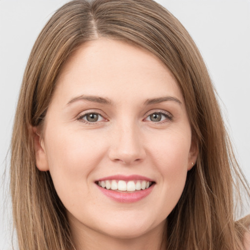 Joyful white young-adult female with long  brown hair and green eyes