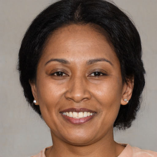 Joyful latino adult female with medium  brown hair and brown eyes