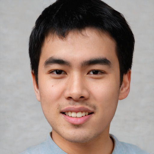 Joyful asian young-adult male with short  black hair and brown eyes