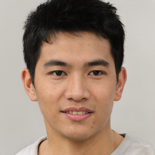 Joyful asian young-adult male with short  brown hair and brown eyes
