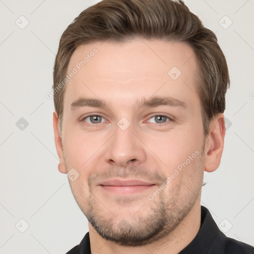 Joyful white young-adult male with short  brown hair and grey eyes