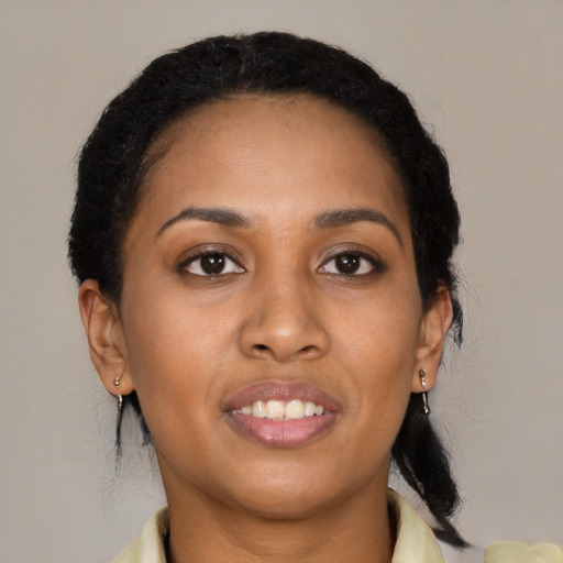 Joyful black young-adult female with long  brown hair and brown eyes