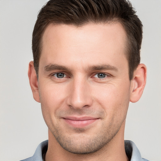 Joyful white young-adult male with short  brown hair and grey eyes