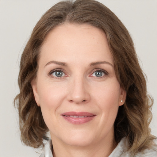 Joyful white adult female with medium  brown hair and grey eyes