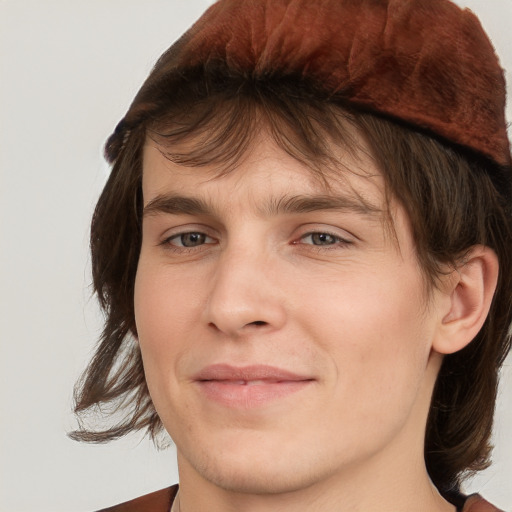 Joyful white young-adult male with medium  brown hair and grey eyes