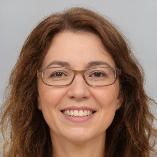 Joyful white adult female with long  brown hair and green eyes