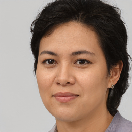 Joyful asian adult female with medium  brown hair and brown eyes