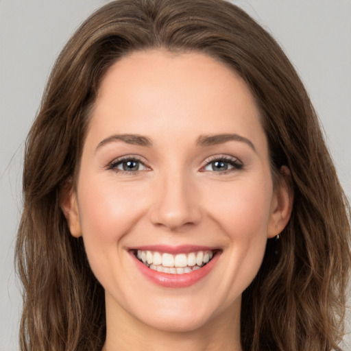 Joyful white young-adult female with long  brown hair and grey eyes