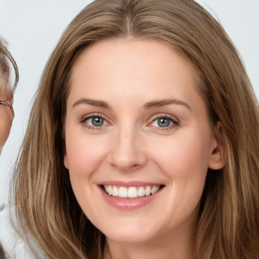 Joyful white young-adult female with long  brown hair and grey eyes