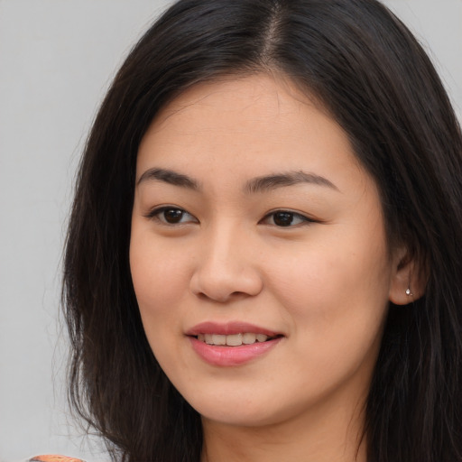 Joyful asian young-adult female with long  brown hair and brown eyes