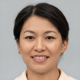 Joyful asian young-adult female with short  brown hair and brown eyes