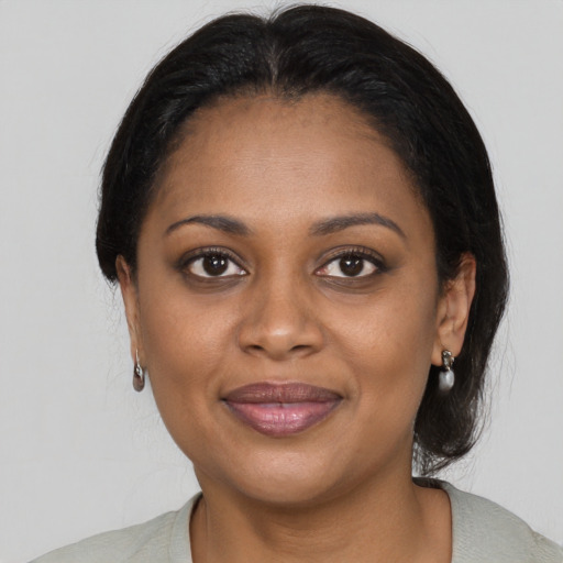 Joyful black young-adult female with medium  brown hair and brown eyes