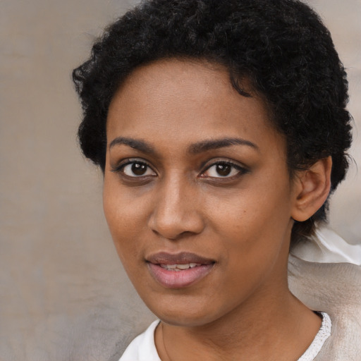 Joyful black young-adult female with short  black hair and brown eyes