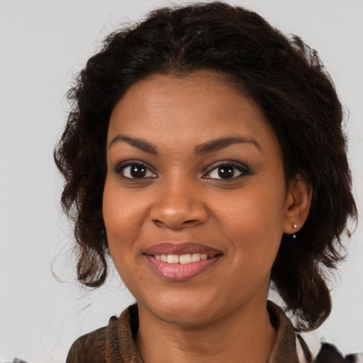 Joyful black young-adult female with long  brown hair and brown eyes