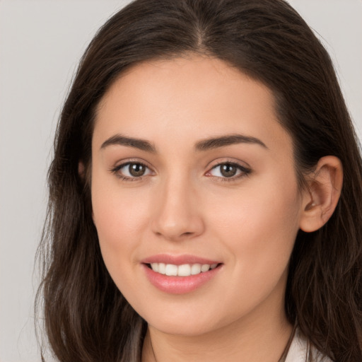 Joyful white young-adult female with long  brown hair and brown eyes