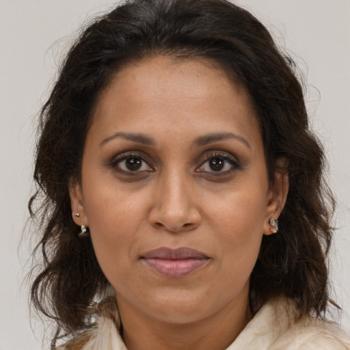 Joyful black adult female with long  brown hair and brown eyes