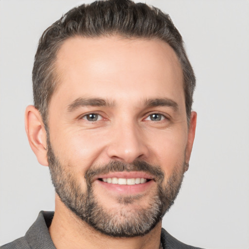 Joyful white adult male with short  brown hair and brown eyes